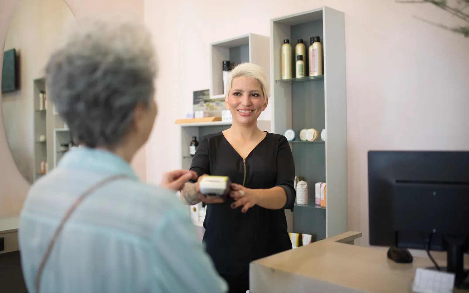 Professionnelle échangeant avec une cliente à l’accueil d’un salon