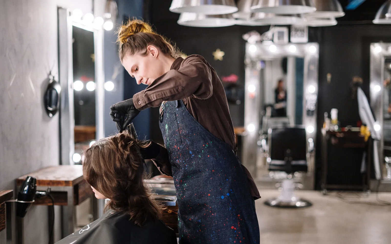 Coiffeuse appliquant une coloration pendant un rendez-vous au salon
