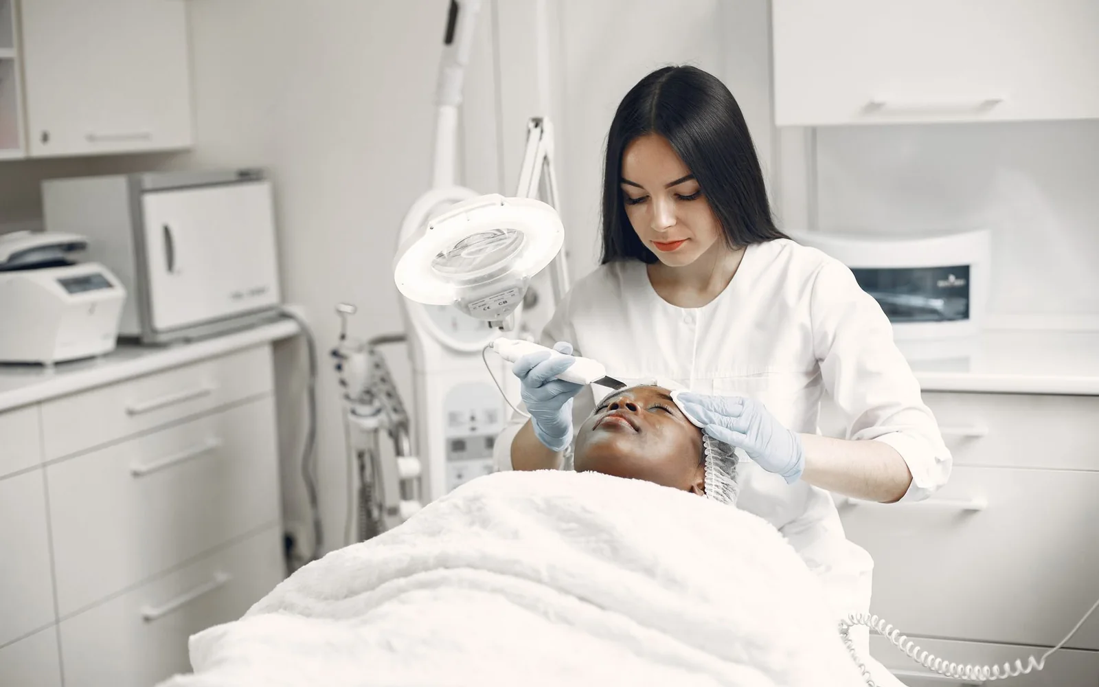 Esthéticienne réalisant un soin du visage en cabine